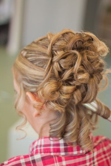 Coiffure Mariée Coiffure élégante avec des boucles en chignon sur cheveux blonds.
